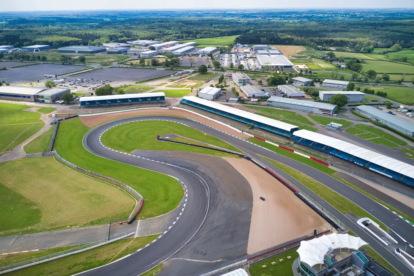 Drone view over the Silverstone circuit track, grandstands and surrounding fields