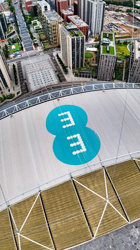 Overhead drone view of Wembley Stadium, London, with a large EE logo on the roof