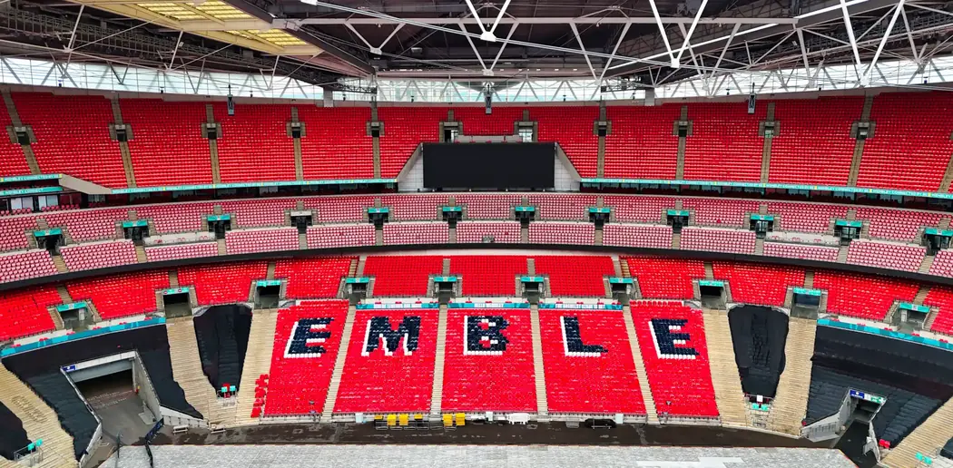 Drone view inside Wembley Stadium, London, with EE lettering across the red seats